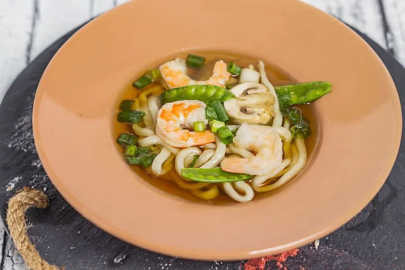 Looking for a slurpy noodle soup? Hawaiian Saimin Soup is an easy broth to make that uses Udon noodles. You will love the flavor of the broth, best of all this homemade soup can be made in 15 minutes! Hawaiian Saimin Soup overhead of soup in bowl