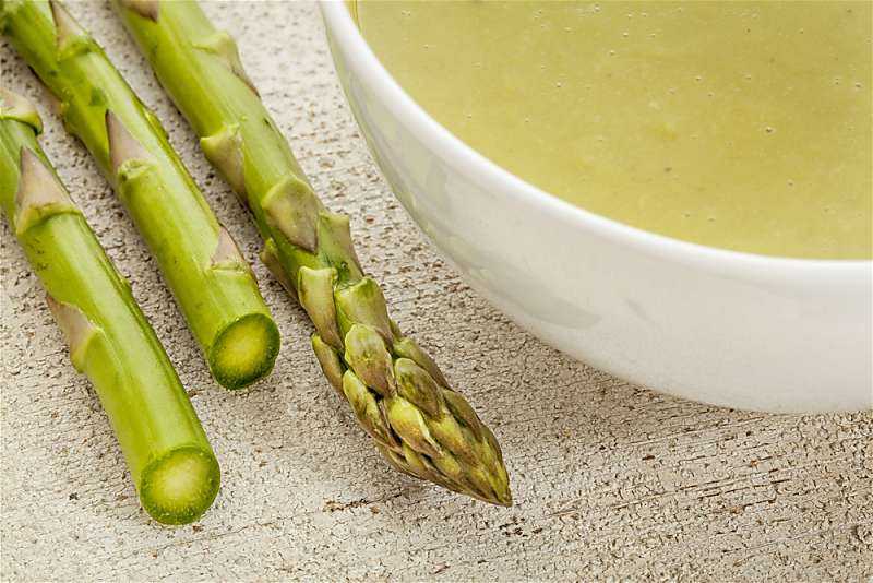 Crock Pot Cream Of Asparagus Soup in white bowl on table