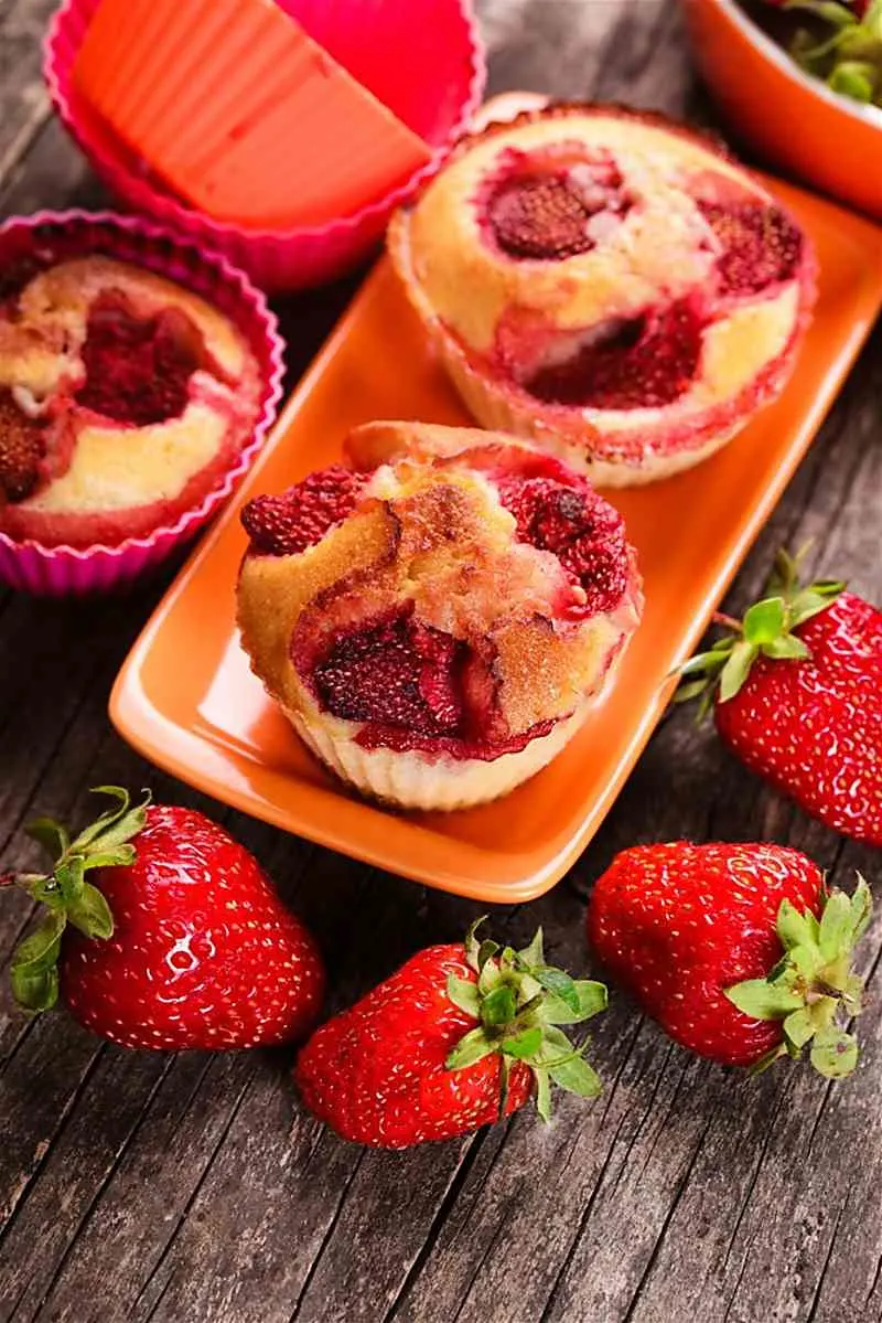 Looking for a breakfast pastry to enjoy in the morning? Mango Strawberry Muffins is so simple to make with fresh fruit. The mango strawberry muffins only take one bowl to make. You will enjoy having this muffin with your morning coffee. mango strawberry muffins surrounded by strawberries