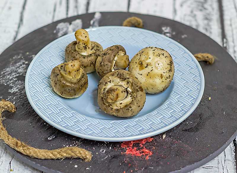 Marinated Garlic Mushrooms wide view mushrooms on blue plate