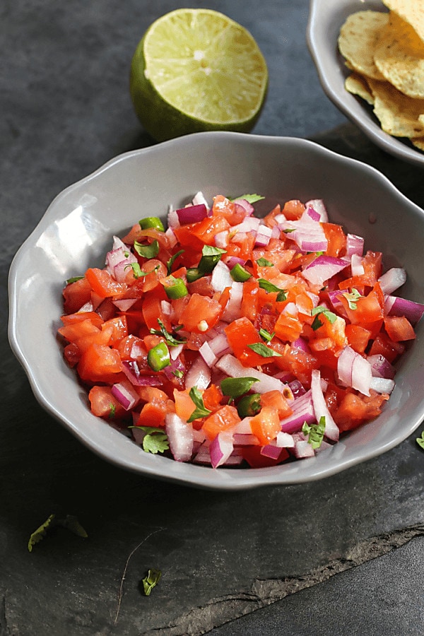 salsa in grey bowl with lime on table