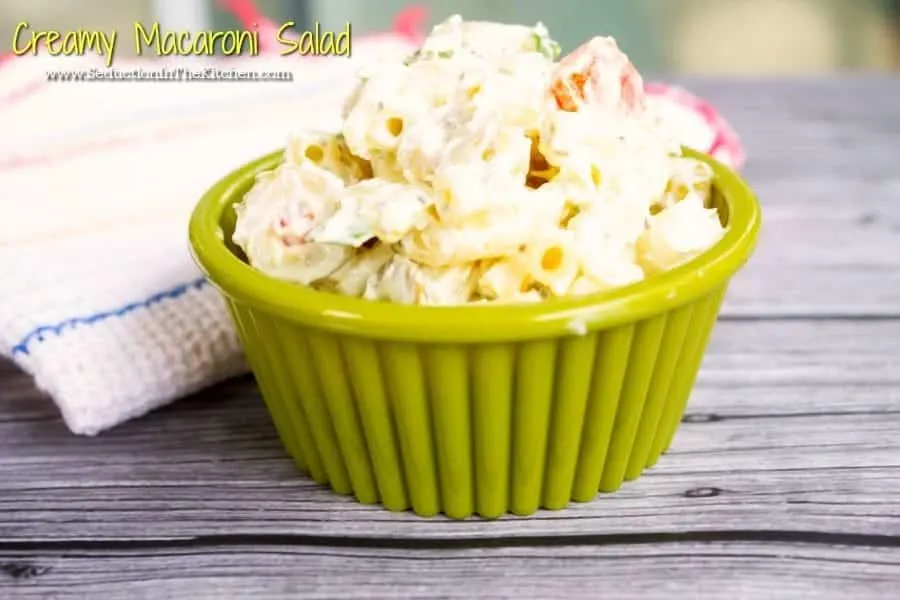 Creamy Macaroni Salad in green cup on grey wooden table