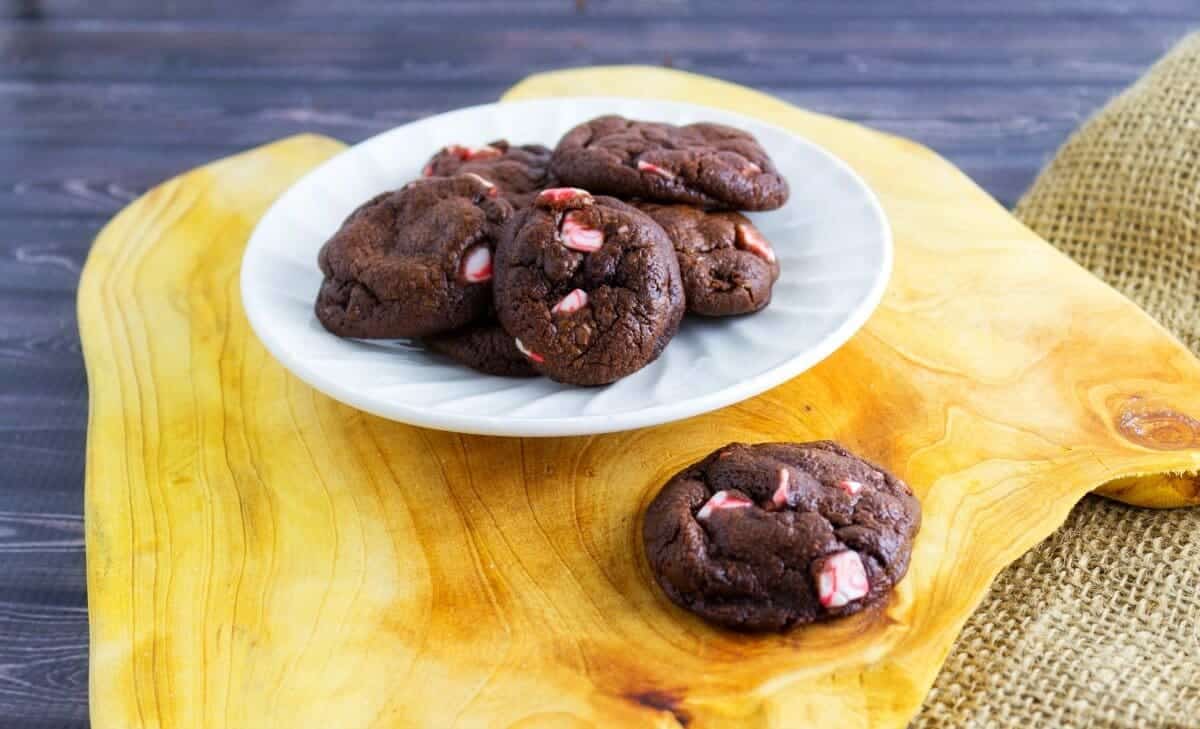 Dark Chocolate Peppermint Crunch Cookies on white plate on a wood cutting board