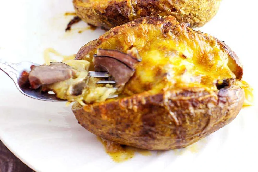 Roast Beef Stuffed Baked Potatoes is a meal in itself. Tender roast beef with caramelized onions and au jus gravy stuffed into a potato than covered with melted cheese. This recipe is a good way to use up leftover roast beef. 