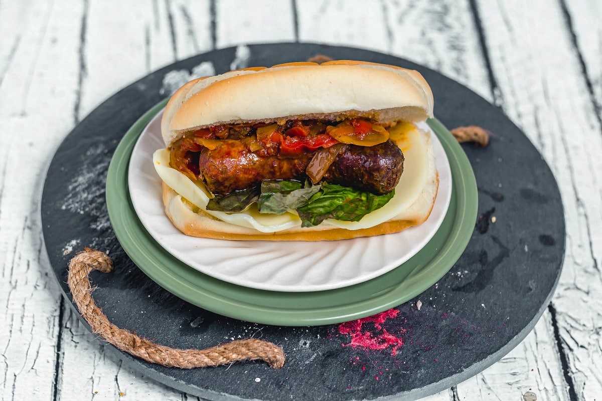 Classic Italian Sausage, Peppers, and Onions Sandwiches Long view on table