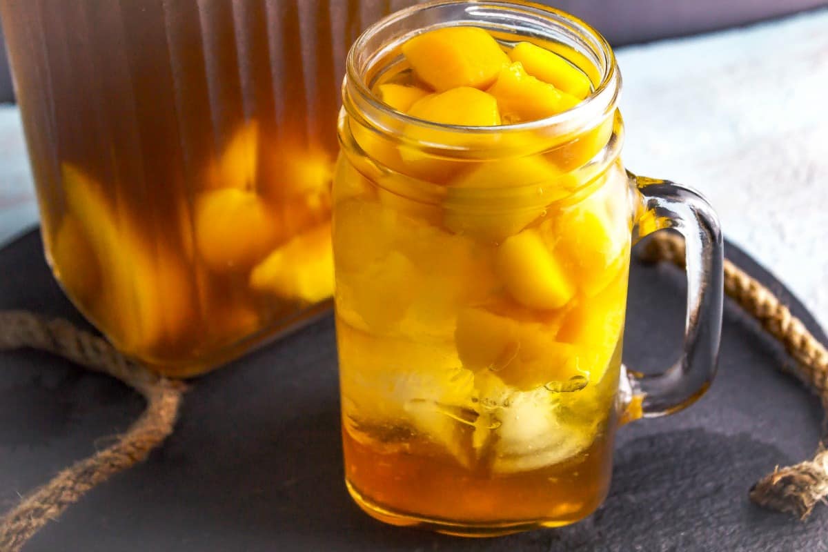 Peach Sweet Tea in mason jar glass on black slate