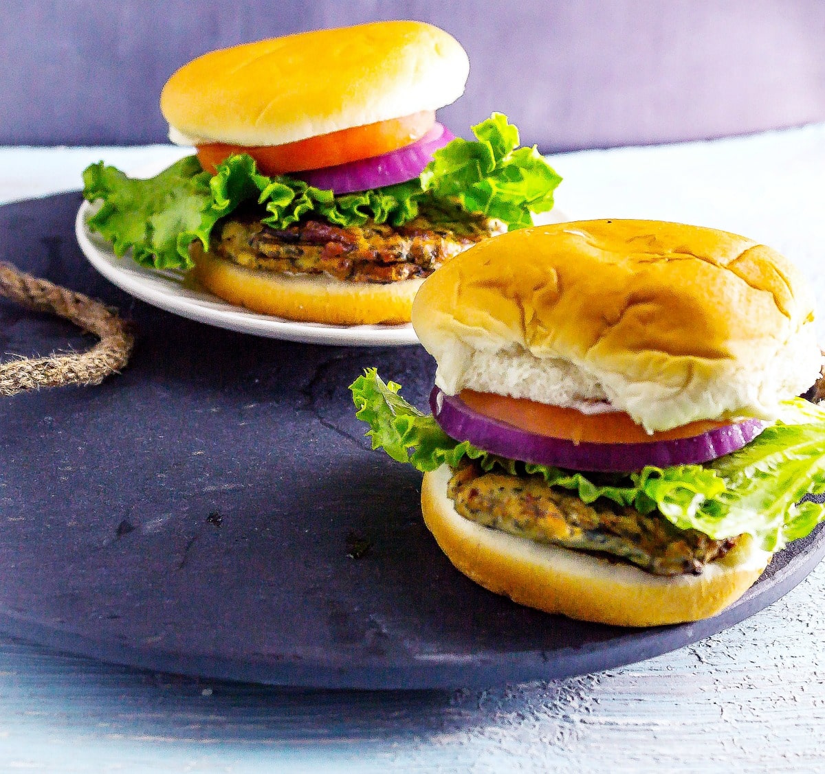 2 Greek Spinach and Feta Chicken Burgers on slate serving tray on table