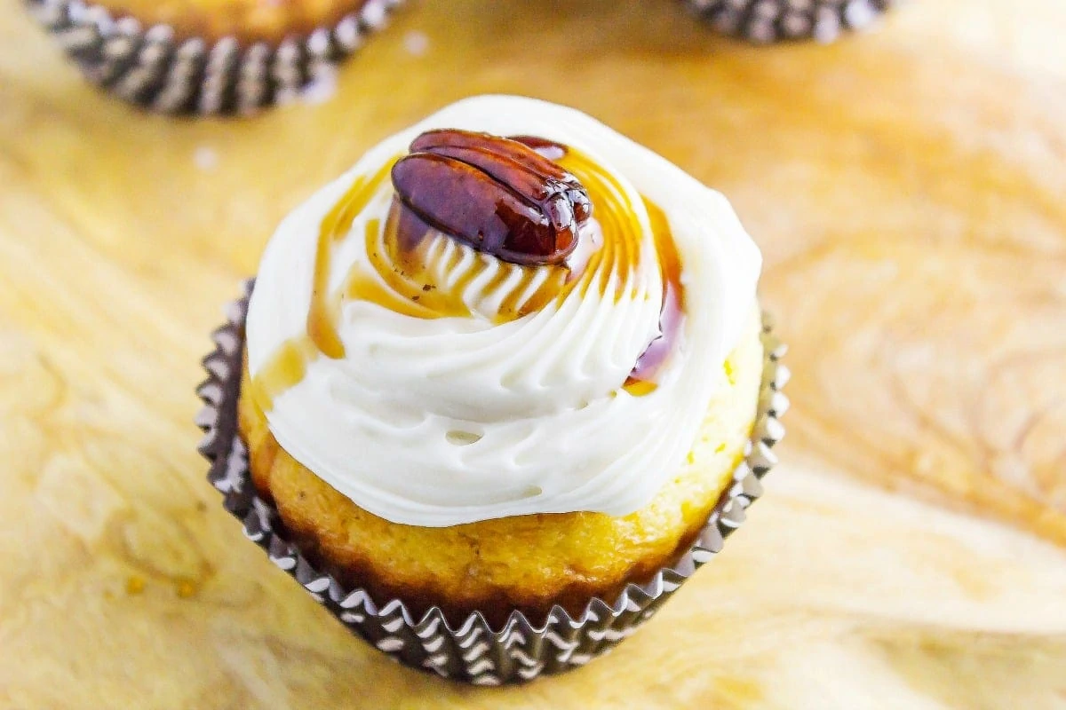 Maple Bacon Bourbon Pecan Cupcakes a sweet treat you can have for breakfast! Maple cream cheese icing adorn a delicious bacon filled cupcakes