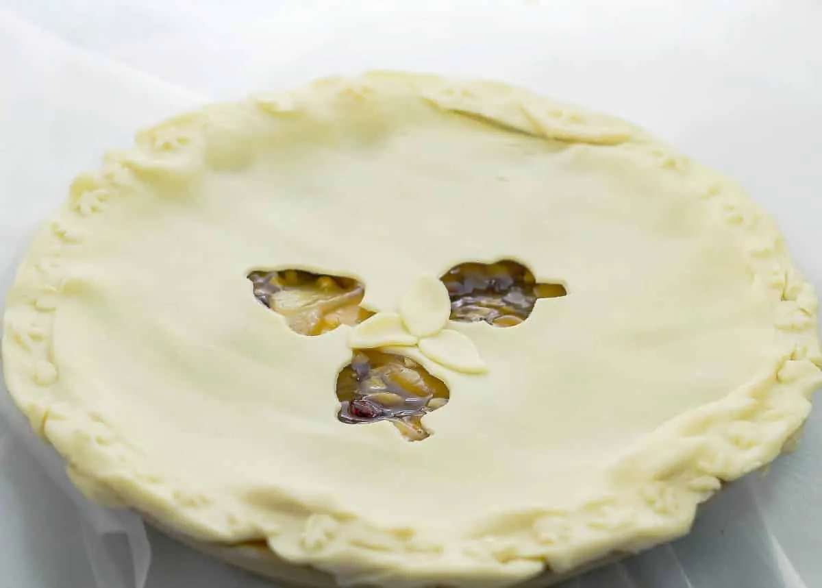 Do you need a last minute dessert? This Apple Pomegranate Walnut Pie is a semi-homemade pie That is perfect for that last minute dessert. Apple Pomegranate Walnut Pie wide shot of pie before baking