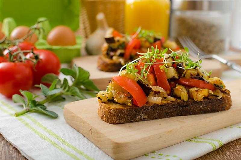 avocado bruschetta on table with food surrounding it