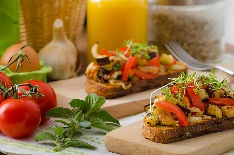 2 avocado bruscetta on wooden boards on a table