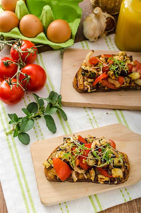 Avocado Bruschetta wide shot on table with green striped tablecloth