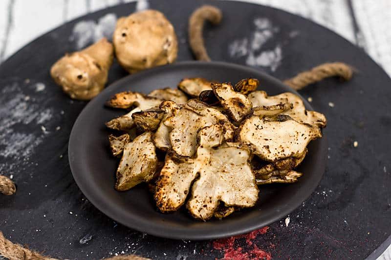 Baked Rosemary And Olive Oil Sunchoke Chips on black plate