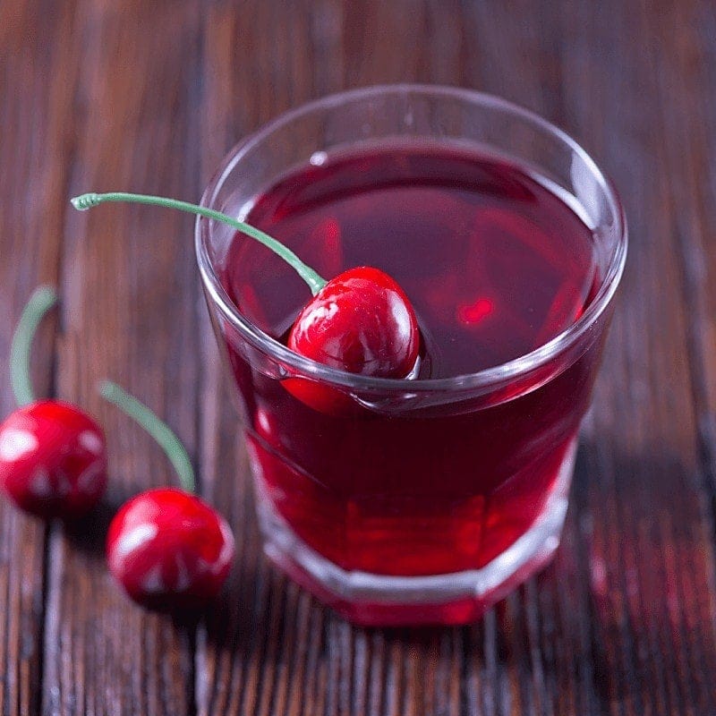 Cherry lime rickey overhead of cockatil with cherry on wood table