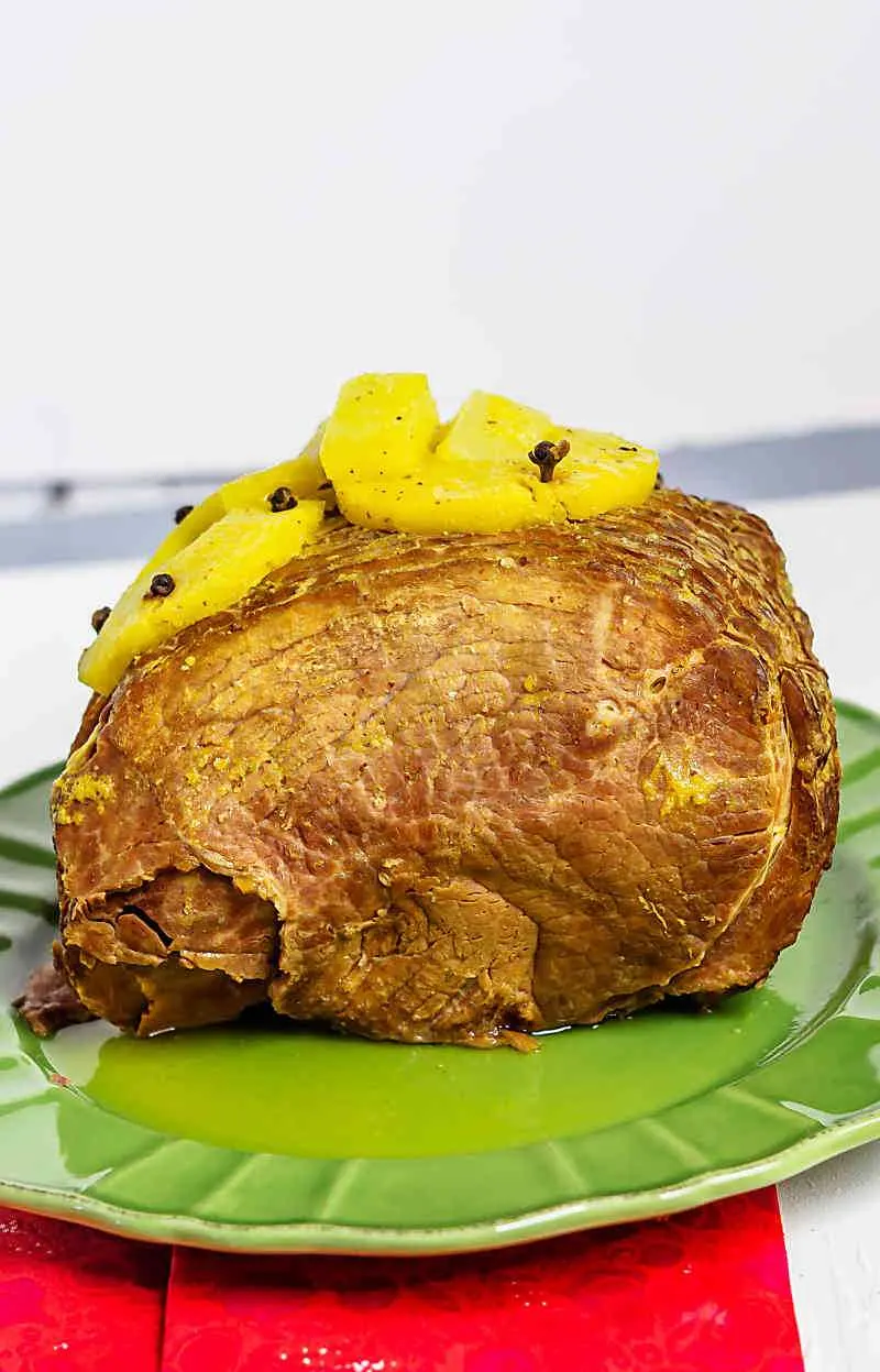 Instant Pot Pineapple Mango ham! It is a simple way to make a holiday ham. Instant Pot Pineapple Mango Ham on green plate with red cloth