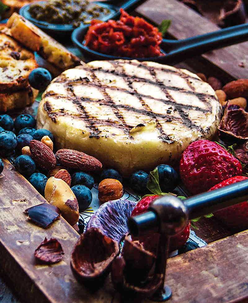 Garlic and rosemary butter grilled brie surrounds by nuts and berries