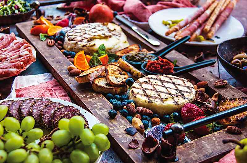 Garlic and Rosemary Butter Grilled Brie on buffeet with fruits and berries