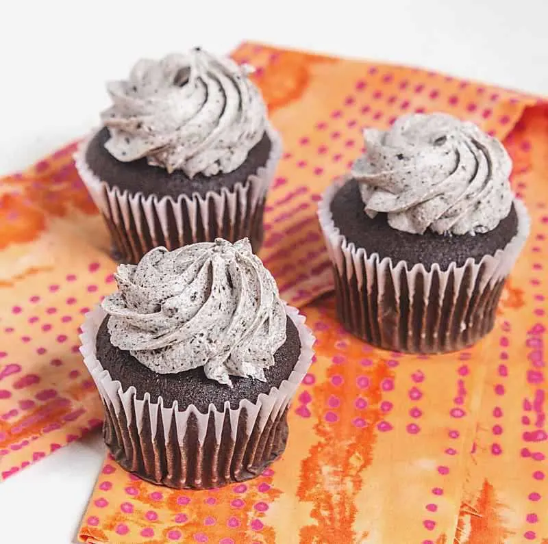 3 grey stuff cupcakes on orange and magenta napkin