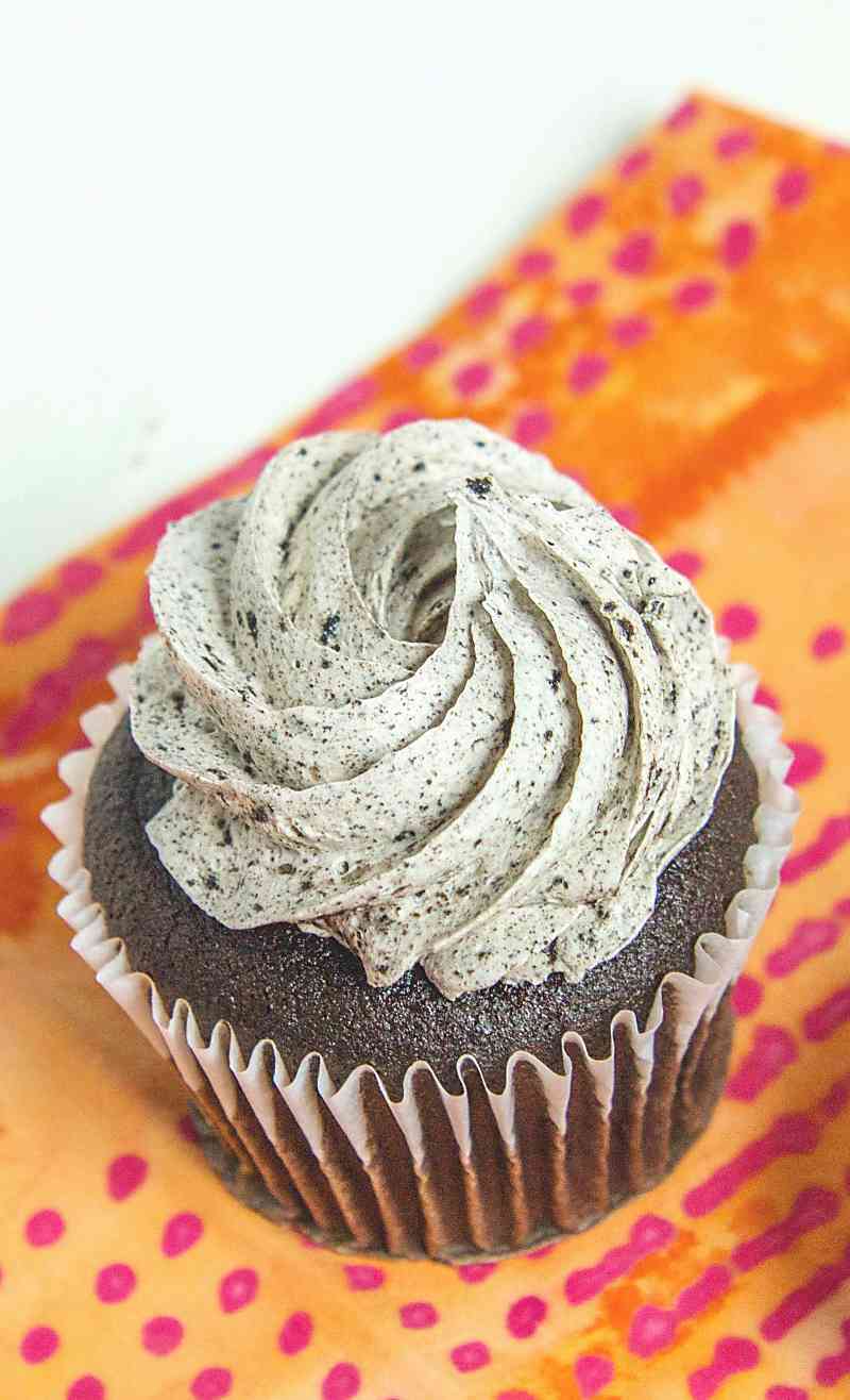 Single grey stuff cupcakes on orange napkin on white background