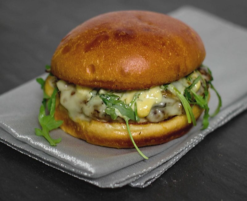 Pesto Portabello Chicken Burger on a silver table cloth on black table