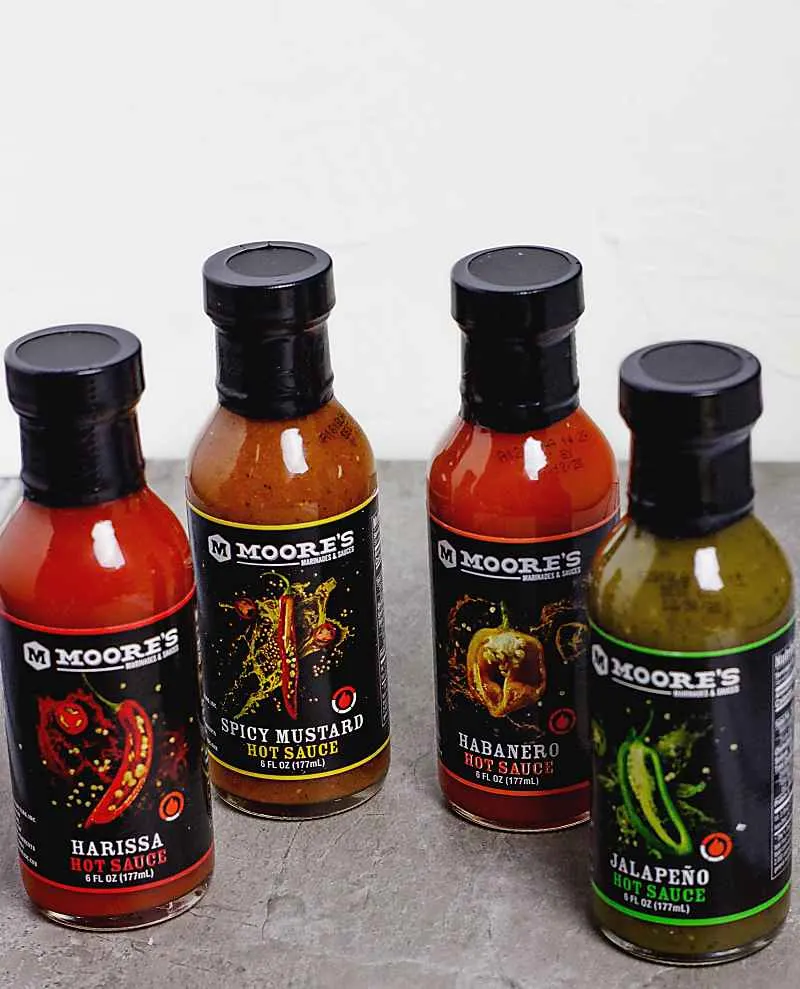 Moore's Marinades new flavors. 4 bottles on a grey marble table top