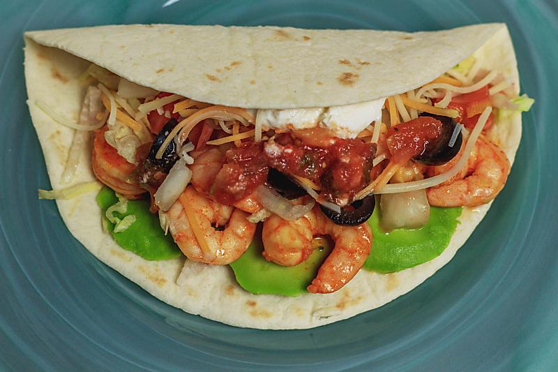 A soft shell shrimp taco with all the toppings 