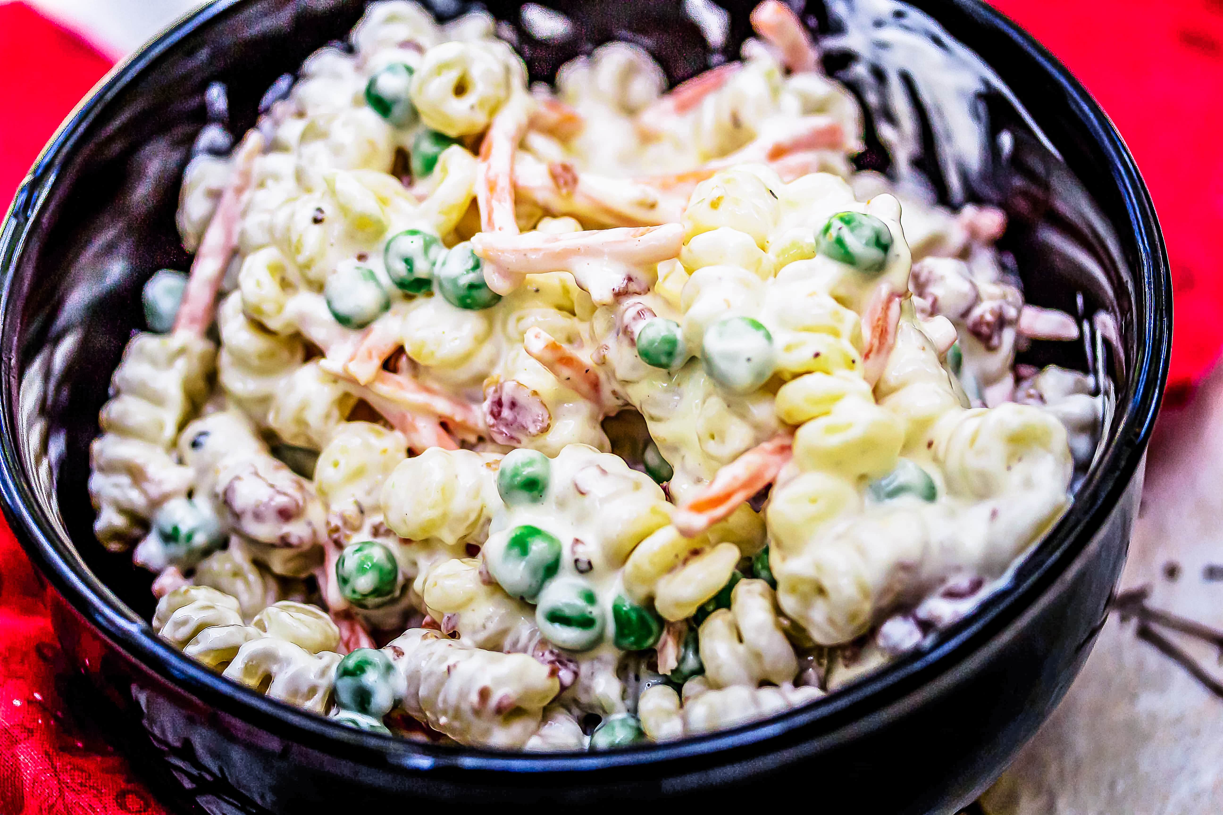 bacon ranch pasta salad in black bowl on red cloth