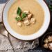 mushroom bisque in white bowl, on dark slate