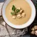 mushroom bisque in white bowl, on dark slate