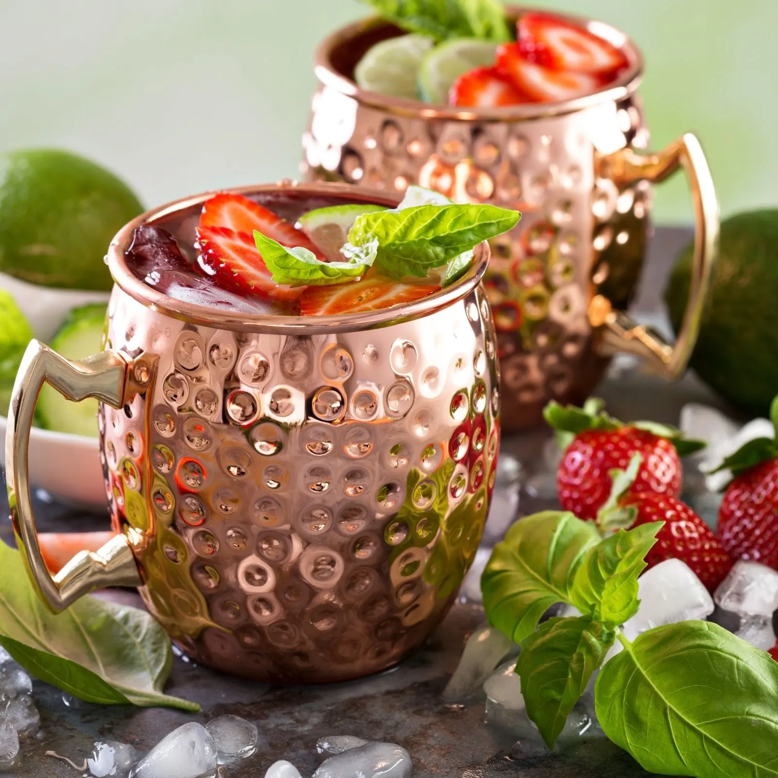 2 Strawberry moscow mules in copper cups and strawberries on top