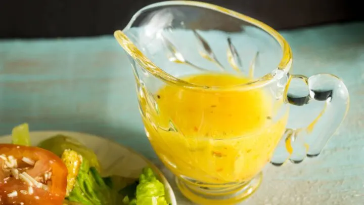 Grilled Peach Balsamic Vinegarette in glass gravy boat next to salad