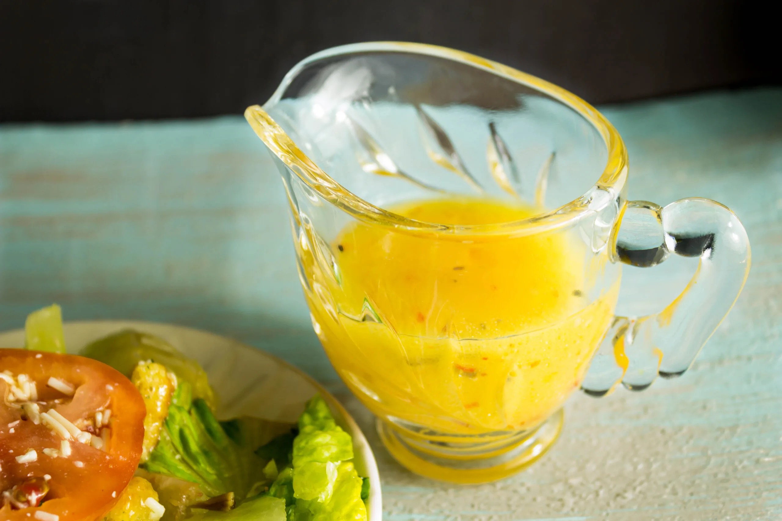 Grilled Peach Balsamic Vinegarette in glass gravy boat next to salad