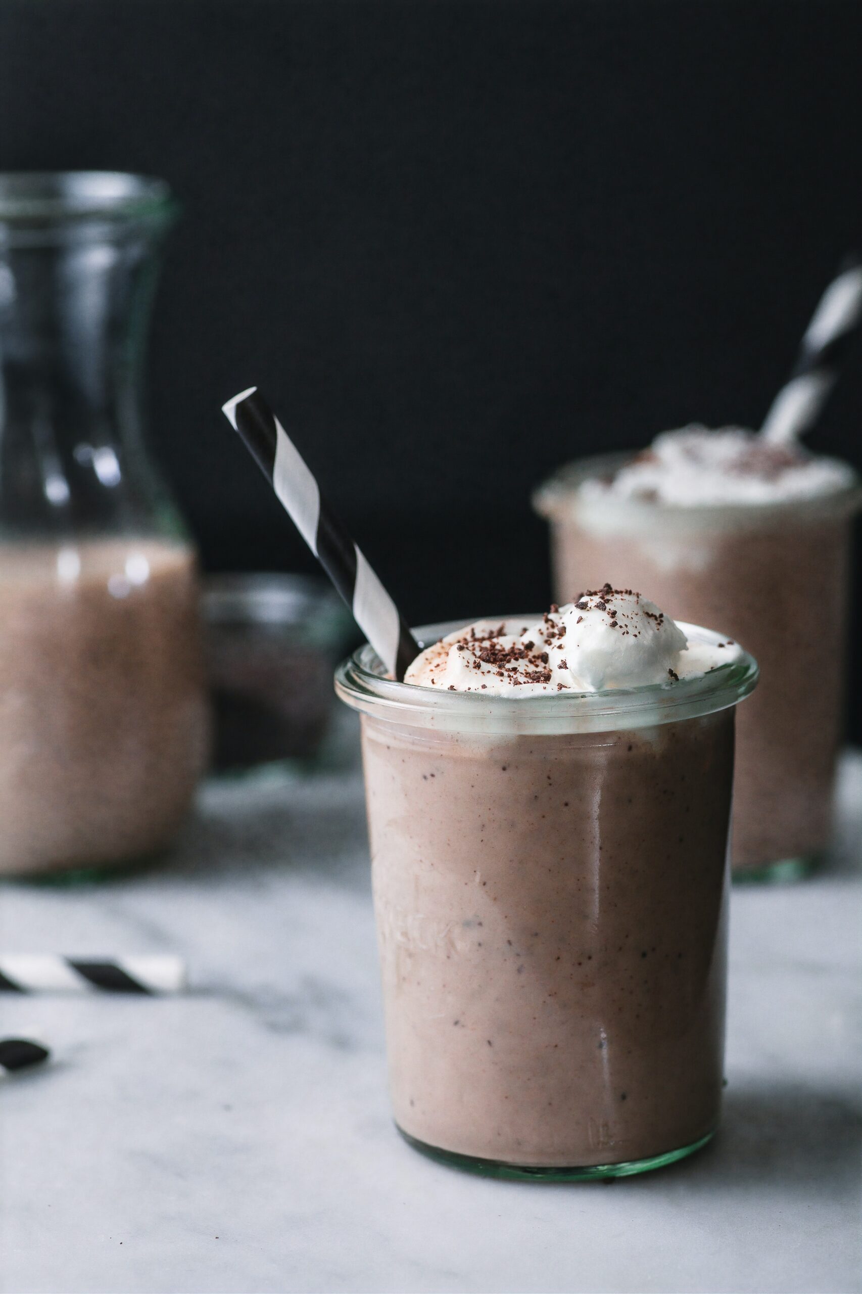 frozen hot chocolate black background on marble surface and a black and white straw